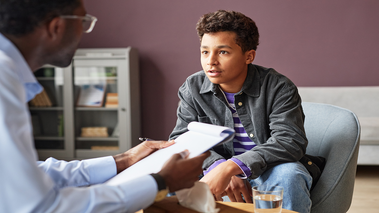 A teenage boy talking to a therapist